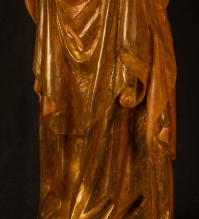 Zdjęcie nr 21: Rzeźba pełnoplastyczna, przyścienna, z tyłu wydrążona. Przedstawienie Matki Boskiej z Dzieciątkiem, ukazanej w całej postaci, frontalnie. Maria stoi w kontrapoście, esowato wygięta, z głową lekko przechyloną w lewo, podtrzymując Dzieciątko ręką wspartą na lewym biodrze. Twarz owalna, o subtelnych rysach, z wysokim czołem, regularnymi łukami brwiowymi i dużymi oczami, długim, wąskim nosem, małymi ustami i wydatnym podbródkiem. Ubrana w długą suknię i narzucony na ramiona płaszcz, przerzucony przez przód sylwetki i układający się poniżej piersi Marii sekwencją fałdów misowych i v-kształtnych. Na głowie źle zachowana chusta spływająca na ramiona. Dzieciątko siedzi na lewym przedramieniu Matki, ze skrzyżowanymi nóżkami, prawą dłonią dotykając piersi Marii, lewą trzyma glob. Twarz okrągła, o drobnych rysach, okolona krótkimi ciemnymi włosami. Jezus ubrany w długą sukienkę, spod której widać bose stopy.   