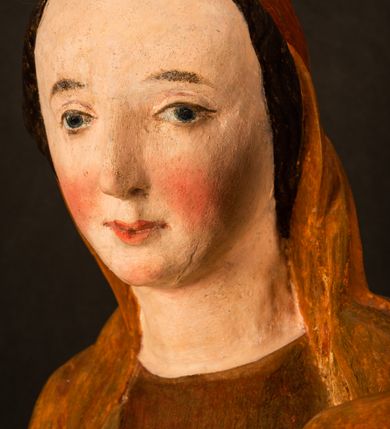 Zdjęcie nr 11: Rzeźba pełnoplastyczna, przyścienna, z tyłu wydrążona. Przedstawienie Matki Boskiej z Dzieciątkiem, ukazanej w całej postaci, frontalnie. Maria stoi w kontrapoście, esowato wygięta, z głową lekko przechyloną w lewo, podtrzymując Dzieciątko ręką wspartą na lewym biodrze. Twarz owalna, o subtelnych rysach, z wysokim czołem, regularnymi łukami brwiowymi i dużymi oczami, długim, wąskim nosem, małymi ustami i wydatnym podbródkiem. Ubrana w długą suknię i narzucony na ramiona płaszcz, przerzucony przez przód sylwetki i układający się poniżej piersi Marii sekwencją fałdów misowych i v-kształtnych. Na głowie źle zachowana chusta spływająca na ramiona. Dzieciątko siedzi na lewym przedramieniu Matki, ze skrzyżowanymi nóżkami, prawą dłonią dotykając piersi Marii, lewą trzyma glob. Twarz okrągła, o drobnych rysach, okolona krótkimi ciemnymi włosami. Jezus ubrany w długą sukienkę, spod której widać bose stopy.   