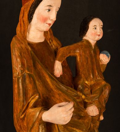 Zdjęcie nr 7: Rzeźba pełnoplastyczna, przyścienna, z tyłu wydrążona. Przedstawienie Matki Boskiej z Dzieciątkiem, ukazanej w całej postaci, frontalnie. Maria stoi w kontrapoście, esowato wygięta, z głową lekko przechyloną w lewo, podtrzymując Dzieciątko ręką wspartą na lewym biodrze. Twarz owalna, o subtelnych rysach, z wysokim czołem, regularnymi łukami brwiowymi i dużymi oczami, długim, wąskim nosem, małymi ustami i wydatnym podbródkiem. Ubrana w długą suknię i narzucony na ramiona płaszcz, przerzucony przez przód sylwetki i układający się poniżej piersi Marii sekwencją fałdów misowych i v-kształtnych. Na głowie źle zachowana chusta spływająca na ramiona. Dzieciątko siedzi na lewym przedramieniu Matki, ze skrzyżowanymi nóżkami, prawą dłonią dotykając piersi Marii, lewą trzyma glob. Twarz okrągła, o drobnych rysach, okolona krótkimi ciemnymi włosami. Jezus ubrany w długą sukienkę, spod której widać bose stopy.   