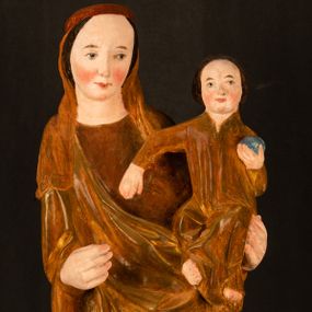 Zdjęcie nr 1: Rzeźba pełnoplastyczna, przyścienna, z tyłu wydrążona. Przedstawienie Matki Boskiej z Dzieciątkiem, ukazanej w całej postaci, frontalnie. Maria stoi w kontrapoście, esowato wygięta, z głową lekko przechyloną w lewo, podtrzymując Dzieciątko ręką wspartą na lewym biodrze. Twarz owalna, o subtelnych rysach, z wysokim czołem, regularnymi łukami brwiowymi i dużymi oczami, długim, wąskim nosem, małymi ustami i wydatnym podbródkiem. Ubrana w długą suknię i narzucony na ramiona płaszcz, przerzucony przez przód sylwetki i układający się poniżej piersi Marii sekwencją fałdów misowych i v-kształtnych. Na głowie źle zachowana chusta spływająca na ramiona. Dzieciątko siedzi na lewym przedramieniu Matki, ze skrzyżowanymi nóżkami, prawą dłonią dotykając piersi Marii, lewą trzyma glob. Twarz okrągła, o drobnych rysach, okolona krótkimi ciemnymi włosami. Jezus ubrany w długą sukienkę, spod której widać bose stopy.   