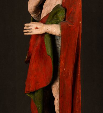 Zdjęcie nr 19: Rzeźba pełna, ustawiona na podstawie na planie ośmioboku oraz na fragmencie podłoża. Chrystus ukazany w całej postaci, frontalnie, prawą, ugiętą rękę unosi w geście błogosławieństwa, lewą trzyma z przodu drzewce chorągwi. Twarz ma podłużną, o migdałowatych, półprzymkniętych oczach, prostym, długim nosie i wąskich ustach. Twarz okolona krótką ciemną brodą oraz falowanymi włosami, opadającymi na ramiona. Przez biodra ma przewiązane białe perizonium, przylegające go ciała. Na ramiona ma narzucony czerwony płaszcz z zieloną podszewką, zawinięty łukowato z przodu postaci i przytrzymywany lewą ręką. Ciało ma wychudzone, o silnie podkreślonych żebrach klatki piersiowej oraz wcięciu w talii, z zaznaczonymi śladami męki. Polichromia ciała naturalistyczna, o jasnej karnacji. Chorągiew wykonana z czerwonej tkaniny wielkowzorzystej. 