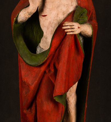 Zdjęcie nr 13: Rzeźba pełna, ustawiona na podstawie na planie ośmioboku oraz na fragmencie podłoża. Chrystus ukazany w całej postaci, frontalnie, prawą, ugiętą rękę unosi w geście błogosławieństwa, lewą trzyma z przodu drzewce chorągwi. Twarz ma podłużną, o migdałowatych, półprzymkniętych oczach, prostym, długim nosie i wąskich ustach. Twarz okolona krótką ciemną brodą oraz falowanymi włosami, opadającymi na ramiona. Przez biodra ma przewiązane białe perizonium, przylegające go ciała. Na ramiona ma narzucony czerwony płaszcz z zieloną podszewką, zawinięty łukowato z przodu postaci i przytrzymywany lewą ręką. Ciało ma wychudzone, o silnie podkreślonych żebrach klatki piersiowej oraz wcięciu w talii, z zaznaczonymi śladami męki. Polichromia ciała naturalistyczna, o jasnej karnacji. Chorągiew wykonana z czerwonej tkaniny wielkowzorzystej. 