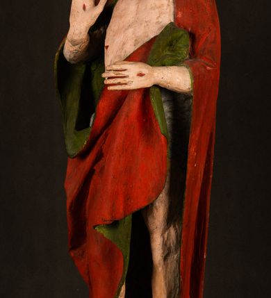 Zdjęcie nr 2: Rzeźba pełna, ustawiona na podstawie na planie ośmioboku oraz na fragmencie podłoża. Chrystus ukazany w całej postaci, frontalnie, prawą, ugiętą rękę unosi w geście błogosławieństwa, lewą trzyma z przodu drzewce chorągwi. Twarz ma podłużną, o migdałowatych, półprzymkniętych oczach, prostym, długim nosie i wąskich ustach. Twarz okolona krótką ciemną brodą oraz falowanymi włosami, opadającymi na ramiona. Przez biodra ma przewiązane białe perizonium, przylegające go ciała. Na ramiona ma narzucony czerwony płaszcz z zieloną podszewką, zawinięty łukowato z przodu postaci i przytrzymywany lewą ręką. Ciało ma wychudzone, o silnie podkreślonych żebrach klatki piersiowej oraz wcięciu w talii, z zaznaczonymi śladami męki. Polichromia ciała naturalistyczna, o jasnej karnacji. Chorągiew wykonana z czerwonej tkaniny wielkowzorzystej. 