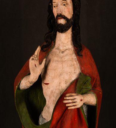 Zdjęcie nr 7: Rzeźba pełna, ustawiona na podstawie na planie ośmioboku oraz na fragmencie podłoża. Chrystus ukazany w całej postaci, frontalnie, prawą, ugiętą rękę unosi w geście błogosławieństwa, lewą trzyma z przodu drzewce chorągwi. Twarz ma podłużną, o migdałowatych, półprzymkniętych oczach, prostym, długim nosie i wąskich ustach. Twarz okolona krótką ciemną brodą oraz falowanymi włosami, opadającymi na ramiona. Przez biodra ma przewiązane białe perizonium, przylegające go ciała. Na ramiona ma narzucony czerwony płaszcz z zieloną podszewką, zawinięty łukowato z przodu postaci i przytrzymywany lewą ręką. Ciało ma wychudzone, o silnie podkreślonych żebrach klatki piersiowej oraz wcięciu w talii, z zaznaczonymi śladami męki. Polichromia ciała naturalistyczna, o jasnej karnacji. Chorągiew wykonana z czerwonej tkaniny wielkowzorzystej. 