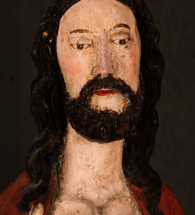 Zdjęcie nr 14: Rzeźba pełna, ustawiona na podstawie na planie ośmioboku oraz na fragmencie podłoża. Chrystus ukazany w całej postaci, frontalnie, prawą, ugiętą rękę unosi w geście błogosławieństwa, lewą trzyma z przodu drzewce chorągwi. Twarz ma podłużną, o migdałowatych, półprzymkniętych oczach, prostym, długim nosie i wąskich ustach. Twarz okolona krótką ciemną brodą oraz falowanymi włosami, opadającymi na ramiona. Przez biodra ma przewiązane białe perizonium, przylegające go ciała. Na ramiona ma narzucony czerwony płaszcz z zieloną podszewką, zawinięty łukowato z przodu postaci i przytrzymywany lewą ręką. Ciało ma wychudzone, o silnie podkreślonych żebrach klatki piersiowej oraz wcięciu w talii, z zaznaczonymi śladami męki. Polichromia ciała naturalistyczna, o jasnej karnacji. Chorągiew wykonana z czerwonej tkaniny wielkowzorzystej. 