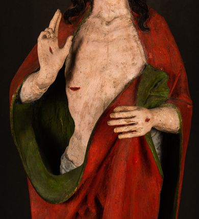 Zdjęcie nr 10: Rzeźba pełna, ustawiona na podstawie na planie ośmioboku oraz na fragmencie podłoża. Chrystus ukazany w całej postaci, frontalnie, prawą, ugiętą rękę unosi w geście błogosławieństwa, lewą trzyma z przodu drzewce chorągwi. Twarz ma podłużną, o migdałowatych, półprzymkniętych oczach, prostym, długim nosie i wąskich ustach. Twarz okolona krótką ciemną brodą oraz falowanymi włosami, opadającymi na ramiona. Przez biodra ma przewiązane białe perizonium, przylegające go ciała. Na ramiona ma narzucony czerwony płaszcz z zieloną podszewką, zawinięty łukowato z przodu postaci i przytrzymywany lewą ręką. Ciało ma wychudzone, o silnie podkreślonych żebrach klatki piersiowej oraz wcięciu w talii, z zaznaczonymi śladami męki. Polichromia ciała naturalistyczna, o jasnej karnacji. Chorągiew wykonana z czerwonej tkaniny wielkowzorzystej. 