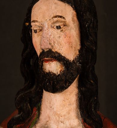 Zdjęcie nr 15: Rzeźba pełna, ustawiona na podstawie na planie ośmioboku oraz na fragmencie podłoża. Chrystus ukazany w całej postaci, frontalnie, prawą, ugiętą rękę unosi w geście błogosławieństwa, lewą trzyma z przodu drzewce chorągwi. Twarz ma podłużną, o migdałowatych, półprzymkniętych oczach, prostym, długim nosie i wąskich ustach. Twarz okolona krótką ciemną brodą oraz falowanymi włosami, opadającymi na ramiona. Przez biodra ma przewiązane białe perizonium, przylegające go ciała. Na ramiona ma narzucony czerwony płaszcz z zieloną podszewką, zawinięty łukowato z przodu postaci i przytrzymywany lewą ręką. Ciało ma wychudzone, o silnie podkreślonych żebrach klatki piersiowej oraz wcięciu w talii, z zaznaczonymi śladami męki. Polichromia ciała naturalistyczna, o jasnej karnacji. Chorągiew wykonana z czerwonej tkaniny wielkowzorzystej. 