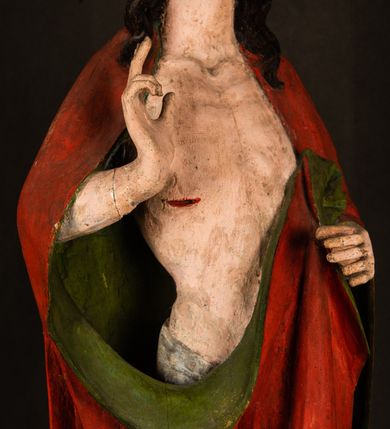 Zdjęcie nr 11: Rzeźba pełna, ustawiona na podstawie na planie ośmioboku oraz na fragmencie podłoża. Chrystus ukazany w całej postaci, frontalnie, prawą, ugiętą rękę unosi w geście błogosławieństwa, lewą trzyma z przodu drzewce chorągwi. Twarz ma podłużną, o migdałowatych, półprzymkniętych oczach, prostym, długim nosie i wąskich ustach. Twarz okolona krótką ciemną brodą oraz falowanymi włosami, opadającymi na ramiona. Przez biodra ma przewiązane białe perizonium, przylegające go ciała. Na ramiona ma narzucony czerwony płaszcz z zieloną podszewką, zawinięty łukowato z przodu postaci i przytrzymywany lewą ręką. Ciało ma wychudzone, o silnie podkreślonych żebrach klatki piersiowej oraz wcięciu w talii, z zaznaczonymi śladami męki. Polichromia ciała naturalistyczna, o jasnej karnacji. Chorągiew wykonana z czerwonej tkaniny wielkowzorzystej. 