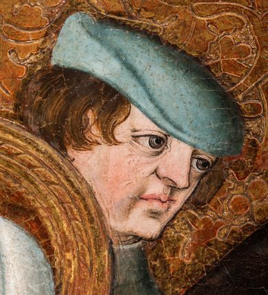 Zdjęcie nr 33: Tryptyk ze sceną Rodziny Marii w polu głównym oraz mniejszymi scenami z życia Najświętszej Marii Panny na rewersie skrzydeł i świętymi na awersie. W polu głównym obraz w formie stojącego prostokąta w drewnianej, profilowanej ramie. W centrum kompozycja przedstawiająca rodzinę Matki Boskiej w ujęciu trójstrefowym. W centrum umieszczona grupa z siedzącymi na kamiennej ławie, wyścielonej zielonym materiałem św. Annę z Dzieciątkiem Jezus oraz Matkę Boską. Obie zwrócone trzy czwarte ku środkowi. Święta Anna dwoma wyciągniętymi przed siebie rękami przytrzymuje stojące na jej kolanach Dzieciątko. Ma szeroką twarz z małymi ustami i dużymi oczami. Ubrana jest w brązową suknię z długimi rękawami oraz czerwony płaszcz z zieloną podszewką, na głowie biały welon w podwiką. Dzieciątko zwrócone jest trzy czwarte w lewo, w lewej dłoni trzyma jabłko, prawą błogosławi. Twarz okrągła o pucułowatych policzkach z wyraźnie zaznaczonym podbródkiem. Włosy krótkie, jasne, kędzierzawe. Matka Boska trzyma na kolanach otwartą księgę, prawą rękę wyciąga do Dzieciątka. Ubrana jest w brązową suknię z długimi rękawami, niebieski płaszcz. Głowę okalają bardzo długie, bujne włosy, opadające falami na ramiona i podwiązane wąska opaską. Wszyscy mają wokół głów złote i tłoczone nimby. U dołu obrazu siedzą z dziećmi: Maria Salome oraz Maria Kleofasowa. Jedna z kobiet karmi piersią niemowlę  (św. Jan Ewangelista), obok siedzi mały św. Jakub Większy, druga uczy czytać dwójkę dzieci (zapewne św. Jakub Mniejszy i św. Juda Tadeusz). Kobiety ubrane w obszerne suknie: zieloną i czerwoną, na głowach mają założone białe czepce. Po prawej stronie obrazu miniaturowa postać fundatora ze złożonymi dłońmi. W górnej części kompozycji za ławą ukazani w półpostaci czterej mężczyźni, nad postacią św. Anny: Joachim, Kleofas i Salomas, a nad Matką Boską – św. Józef. Tło obrazu złocone i tłoczone w motywy roślinne. Kwatery dwudzielne, w lewej na awersie u dołu scena Nawiedzenia Najświętszej Marii Panny, u góry Zwiastowanie. Na awersie prawego skrzydła u dołu niezachowana scena, a u góry Pokłon Trzech Króli. Na rewersach skrzydeł: po lewej u góry św. Florian i św. Wojciech, niżej św. Stanisław i biskupa bez atrybutu (św. Mikołaj?); na prawym skrzydle u góry św. Bartłomiej i św. Paweł, u dołu brak kwatery. 