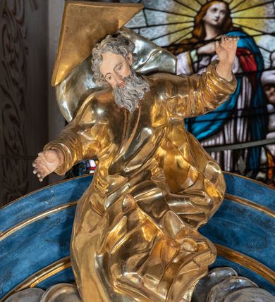 Zdjęcie nr 30: Ołtarz architektoniczny, jednoosiowy, jednokondygnacyjny ze zwieńczeniem. Na zdwojonych cokołach usytuowanych ukośnie względem osi po trzy kompozytowe kolumny opinające filary o gładkich trzonach podtrzymujących wyłamujące się nad nimi belkowanie z ćwierćkolistymi naczółkami. Na nich siedzące anioły z narzędzami męki Pańskiej. Pośrodku wnęka zamknięta półkoliście i wchodząca w partię belkowania z figurą Ukrzyżowanego. Nad wnęką dwa nagie putta trzymają kartusz z napisem: &quot;DZIEŁO / NIE MAJĄC PRZYKŁADU / ŁASKA NIE ZASŁUŻONA / DAR NIE OCENIONY / MIŁOŚĆ BEZ GRANIC&quot;.  Zwieńczenie ujęte spływami wolutowymi, mocno zwężające się ku górze, zakończone gzymsem w formie łuku nadwieszonego. W polu owalny prześwit z glorią promienistą w chmurach z figurą Boga Ojca, puttami siedzącymi na gzymsie i główkami aniołów wśród chmur. Po bokach ołtarza dwie bramki z cokołami ujętymi spływami wolutowymi, na których figury św. Jana Chrzciciela i św. Jana Ewangelisty. Dekoracja ornamentalna w postaci rozłożystych liści na cokołach oraz liściastych, ażurowych uszy ujmujących nastawę. 