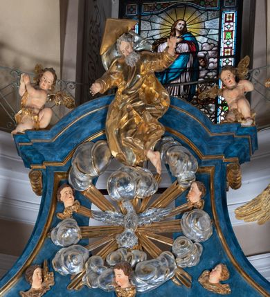 Zdjęcie nr 35: Ołtarz architektoniczny, jednoosiowy, jednokondygnacyjny ze zwieńczeniem. Na zdwojonych cokołach usytuowanych ukośnie względem osi po trzy kompozytowe kolumny opinające filary o gładkich trzonach podtrzymujących wyłamujące się nad nimi belkowanie z ćwierćkolistymi naczółkami. Na nich siedzące anioły z narzędzami męki Pańskiej. Pośrodku wnęka zamknięta półkoliście i wchodząca w partię belkowania z figurą Ukrzyżowanego. Nad wnęką dwa nagie putta trzymają kartusz z napisem: &quot;DZIEŁO / NIE MAJĄC PRZYKŁADU / ŁASKA NIE ZASŁUŻONA / DAR NIE OCENIONY / MIŁOŚĆ BEZ GRANIC&quot;.  Zwieńczenie ujęte spływami wolutowymi, mocno zwężające się ku górze, zakończone gzymsem w formie łuku nadwieszonego. W polu owalny prześwit z glorią promienistą w chmurach z figurą Boga Ojca, puttami siedzącymi na gzymsie i główkami aniołów wśród chmur. Po bokach ołtarza dwie bramki z cokołami ujętymi spływami wolutowymi, na których figury św. Jana Chrzciciela i św. Jana Ewangelisty. Dekoracja ornamentalna w postaci rozłożystych liści na cokołach oraz liściastych, ażurowych uszy ujmujących nastawę. 