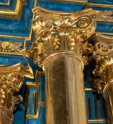 Zdjęcie nr 75: Ołtarz architektoniczny, jednoosiowy, jednokondygnacyjny ze zwieńczeniem. Na zdwojonych cokołach usytuowanych ukośnie względem osi po trzy kompozytowe kolumny opinające filary o gładkich trzonach podtrzymujących wyłamujące się nad nimi belkowanie z ćwierćkolistymi naczółkami. Na nich siedzące anioły z narzędzami męki Pańskiej. Pośrodku wnęka zamknięta półkoliście i wchodząca w partię belkowania z figurą Ukrzyżowanego. Nad wnęką dwa nagie putta trzymają kartusz z napisem: &quot;DZIEŁO / NIE MAJĄC PRZYKŁADU / ŁASKA NIE ZASŁUŻONA / DAR NIE OCENIONY / MIŁOŚĆ BEZ GRANIC&quot;.  Zwieńczenie ujęte spływami wolutowymi, mocno zwężające się ku górze, zakończone gzymsem w formie łuku nadwieszonego. W polu owalny prześwit z glorią promienistą w chmurach z figurą Boga Ojca, puttami siedzącymi na gzymsie i główkami aniołów wśród chmur. Po bokach ołtarza dwie bramki z cokołami ujętymi spływami wolutowymi, na których figury św. Jana Chrzciciela i św. Jana Ewangelisty. Dekoracja ornamentalna w postaci rozłożystych liści na cokołach oraz liściastych, ażurowych uszy ujmujących nastawę. 