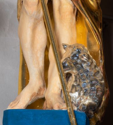 Zdjęcie nr 73: Ołtarz architektoniczny, jednoosiowy, jednokondygnacyjny ze zwieńczeniem. Na zdwojonych cokołach usytuowanych ukośnie względem osi po trzy kompozytowe kolumny opinające filary o gładkich trzonach podtrzymujących wyłamujące się nad nimi belkowanie z ćwierćkolistymi naczółkami. Na nich siedzące anioły z narzędzami męki Pańskiej. Pośrodku wnęka zamknięta półkoliście i wchodząca w partię belkowania z figurą Ukrzyżowanego. Nad wnęką dwa nagie putta trzymają kartusz z napisem: "DZIEŁO / NIE MAJĄC PRZYKŁADU / ŁASKA NIE ZASŁUŻONA / DAR NIE OCENIONY / MIŁOŚĆ BEZ GRANIC".  Zwieńczenie ujęte spływami wolutowymi, mocno zwężające się ku górze, zakończone gzymsem w formie łuku nadwieszonego. W polu owalny prześwit z glorią promienistą w chmurach z figurą Boga Ojca, puttami siedzącymi na gzymsie i główkami aniołów wśród chmur. Po bokach ołtarza dwie bramki z cokołami ujętymi spływami wolutowymi, na których figury św. Jana Chrzciciela i św. Jana Ewangelisty. Dekoracja ornamentalna w postaci rozłożystych liści na cokołach oraz liściastych, ażurowych uszy ujmujących nastawę. 