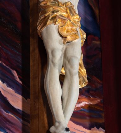 Zdjęcie nr 47: Ołtarz architektoniczny, jednoosiowy, jednokondygnacyjny ze zwieńczeniem. Na zdwojonych cokołach usytuowanych ukośnie względem osi po trzy kompozytowe kolumny opinające filary o gładkich trzonach podtrzymujących wyłamujące się nad nimi belkowanie z ćwierćkolistymi naczółkami. Na nich siedzące anioły z narzędzami męki Pańskiej. Pośrodku wnęka zamknięta półkoliście i wchodząca w partię belkowania z figurą Ukrzyżowanego. Nad wnęką dwa nagie putta trzymają kartusz z napisem: "DZIEŁO / NIE MAJĄC PRZYKŁADU / ŁASKA NIE ZASŁUŻONA / DAR NIE OCENIONY / MIŁOŚĆ BEZ GRANIC".  Zwieńczenie ujęte spływami wolutowymi, mocno zwężające się ku górze, zakończone gzymsem w formie łuku nadwieszonego. W polu owalny prześwit z glorią promienistą w chmurach z figurą Boga Ojca, puttami siedzącymi na gzymsie i główkami aniołów wśród chmur. Po bokach ołtarza dwie bramki z cokołami ujętymi spływami wolutowymi, na których figury św. Jana Chrzciciela i św. Jana Ewangelisty. Dekoracja ornamentalna w postaci rozłożystych liści na cokołach oraz liściastych, ażurowych uszy ujmujących nastawę. 