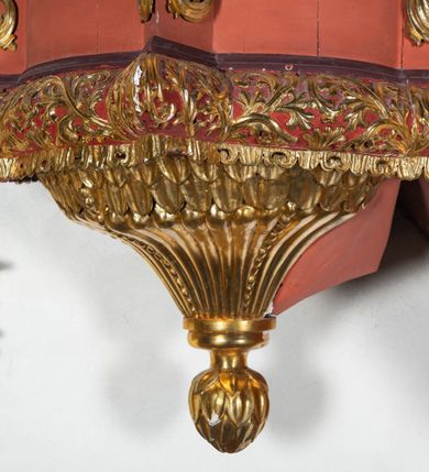 Zdjęcie nr 5: Ambona przyścienna dostępna jednotraktraktowymi schodami z pełną balustradą od strony wschodniej. Kosz na rzucie owalnym, opięty dostawionymi do boków pilastrami na rzucie trójkąta. W dolnej części złocony z podwieszoną szyszką. Podstawa walcowato wypukła dekorowana suchym akantem i jajownikiem. W polach kosza płyciny w kształcie stojącego prostokąta z symetryczną, złoconą dekoracją akantową. Trzony pilastrów wypełnione złoconym akantem o esowatym przebiegu wici. W zwieńczeniu wypukły, profilowany gzyms dekorowany palmetami I jajownikiem. Balustrada schodów zakończona pilastrem z prostokątną płyciną. W polu złocona dekoracją z suchego akantu. Struktura malowana w odcieniach ciemnej czerwieni i brązu, ornamentyka złocona.