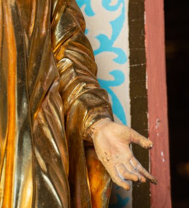 Zdjęcie nr 9: Rzeźba ścięta z tyłu, ustawiona na cokole. Święty ukazany frontalnie, w kontrapoście, z głową skierowaną w prawo. Lewą rękę ma opuszczonĄ w dół, prawą podtrzymuje zamkniętĄ księgę. Twarz ma kwadratową, o dużych, migdałowatych oczach, krótkim, prostym nosie i wąskich ustach, okolonĄ krótkimi, kręconymi włosami i brodą. Na głowie ma biret. Ubrany jest w togę profesorską o szerokich rękawach, z załogą (pelerynką). Polichromia ciała naturalistyczna, szaty i atrybuty złocone. 
