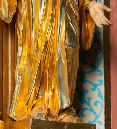 Zdjęcie nr 3: Rzeźba ścięta z tyłu, ustawiona na cokole. Święty ukazany frontalnie, w kontrapoście, z głową skierowaną w prawo. Lewą rękę ma opuszczonĄ w dół, prawą podtrzymuje zamkniętĄ księgę. Twarz ma kwadratową, o dużych, migdałowatych oczach, krótkim, prostym nosie i wąskich ustach, okolonĄ krótkimi, kręconymi włosami i brodą. Na głowie ma biret. Ubrany jest w togę profesorską o szerokich rękawach, z załogą (pelerynką). Polichromia ciała naturalistyczna, szaty i atrybuty złocone. 
