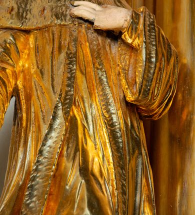 Zdjęcie nr 5: Rzeźba ścięta z tyłu, ustawiona na cokole. Święty ukazany frontalnie, w kontrapoście, z głową skierowaną w lewo. Prawą rękę ma opuszczoną, lewa spoczywa na piersi. Twarz ma kwadratową, o wyodrębnionej brodzie, młodzieńczych rysach, dużych, migdałowatych oczach, krótkim, prostym nosie i wąskich, rozchylonych ustach, okoloną krótkimi, kręconymi, brązowymi włosami. Na głowie ma mitrę książęcą. Ubrany jest w długą tunikę oraz rozchylony z przodu płaszcz królewski, o szerokich rękawach, z gronostajową pelerynką. Polichromia w partiach ciała naturalistyczna, szaty złocone. 

