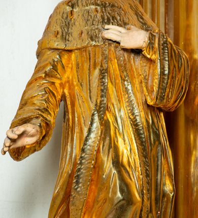 Zdjęcie nr 6: Rzeźba ścięta z tyłu, ustawiona na cokole. Święty ukazany frontalnie, w kontrapoście, z głową skierowaną w lewo. Prawą rękę ma opuszczoną, lewa spoczywa na piersi. Twarz ma kwadratową, o wyodrębnionej brodzie, młodzieńczych rysach, dużych, migdałowatych oczach, krótkim, prostym nosie i wąskich, rozchylonych ustach, okoloną krótkimi, kręconymi, brązowymi włosami. Na głowie ma mitrę książęcą. Ubrany jest w długą tunikę oraz rozchylony z przodu płaszcz królewski, o szerokich rękawach, z gronostajową pelerynką. Polichromia w partiach ciała naturalistyczna, szaty złocone. 

