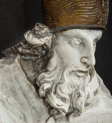 Zdjęcie nr 5: Rzeźba w całej postaci ukazuje frontalnie św. Augustyna ujętego w mocnym kontrapoście. Święty podniesioną prawą ręką trzyma pastorał, lewą zaś zdaje się odbierać rybę podawana mu przez nagie putto widniejące u jego stóp. Biskup w wysokiej infule ma pociągłą twarz o zapadniętych policzkach otoczoną rozwianą, długa brodą oraz kędzierzawymi włosami wystającymi spod złoconej infuły. Jego twarz charakteryzuje wydatny nos i usta. Ubrany jest w rozwianą mocno drapowaną sutannę, komżę obszytą u spodu frędzlą oraz kapę spiętą pod szyją. Spod sutanny widoczny jest stopa obuta w trzewik. Nagie putto u stóp biskua zostało ukazane w kontrapoście w trzech czwartych w prawo. Obiema rękami podaje świętemu rybę. Fragment jego biodra zasłani rozwiana tkanina. Putto wraz z biskupem stoją na fragmencie brzegu. 