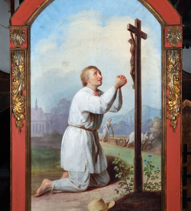 Zdjęcie nr 5: Obraz w kształcie stojącego prostokąta zamkniętego łukiem odcinkowym, w drewnianej szerokiej ramie, malowanej na czerwono i zdobionej złoconymi motywami liści akantu. Na pierwszym planie klęczący święty, ukazany w trzech czwartych, w lewo, w chłopskiej, białej tunice spiętej pod szyją czerwoną wstążką i przepasanej na biodrach brązowym paskiem oraz w spodniach. Ręce wznosi ku górze, w geście modlitwy. Jego twarz o miękkich rysach, zaoblonym nosie, pełnych wargach i płytkich oczodołach wyraża żar wygłaszanej modlitwy. Włosy ma jasne, zaczesane do tyłu. Święty Izydor klęczy przed krzyżem z figurą Chrystusa, ukazanego w silnym skrócie perspektywicznym, na niewielkim ukwieconym pagórku, na którym leży kapelusz. W tle anioł z pługiem zaprzężonym w dwa woły, fragment kościoła w części zasłoniętego starodrzewiem oraz las z pagórkowatym krajobrazem. Niebo jasne, błękitne, zasłonięte w części szarymi chmurami. W prawym dolnym rogu sygnatura „mal[ował] Wojciech Eljasz / 1853”. Na odwrocie „Za staraniem X[iądz] Wojciecha Jenczego / Administratorka Parafii Zielonek / malowano w Krakowie / r[oku] 1853.”