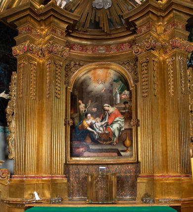 Zdjęcie nr 46: Nastawa architektoniczna, jednokondygnacyjna z glorią, jednoosiowa z bramkami, ustawiona na dwustrefowym cokole, na planie półowalu. Ołtarz kamienny, prostopadłościenny, z wcięciami na bocznych ściankach, zakończony profilowanym gzymsem; mensa kamienna. Na ściance frontowej namalowana scena Ostatniej Wieczerzy. Na ołtarzu ustawione drewniane tabernakulum obite blachą, w formie prostopadłościanu o wypukłych bokach, w narożach ujętego pilastrami o kanelowanych trzonach, dźwigającymi profilowany gzyms. Drzwiczki dwuskrzydłowe, w formie stojącego prostokąta zamkniętego łukiem półkolistym nadwieszonym, ujęty ramą z przedstawieniem baranka stojącego na ołtarzu, z którego piersi wypływa krew do kielicha; w górnej części monogram IHS. Nastawa ujęta dwiema parami filarów ustawionych pod kątem, o kanelowanych trzonach, dekorowanych kampanulami, podtrzymujących pełne belkowanie wyłamane na ich osi, z silnie wysuniętym gzymsem. Fryz zdobiony ornamentem roślinnym, w jego centrum kartusz z napisem „SANCTVS”. Na belkowaniu fragmenty zdwojonego, półkolistego przyczółka, z siedzącymi puttami. Pole główne wypełnione wnęką w formie stojącego prostokąta zamkniętego łukiem półkolistym nadwieszonym, ujęta profilowaną ramą, z obrazem Narodzenia Najświętszej Marii Panny. W przyłuczach dekoracja roślinna. Nastawa flankowana uszami utworzonymi z karbowanej wstęgi i ornamentu roślinnego. W miejscu zwieńczenia gołębica Ducha Świętego w otoku z obłoków i uskrzydlonych główek anielskich, w glorii promienistej. Bramki z drzwiczkami w formie stojącego prostokąta o wklęsłych górnych narożach ze ślimacznicami, ujęte grubą opaską, zwieńczone kluczem z herbem Uniwersytetu Jagiellońskiego oraz fragmentem profilowanego gzymsu, który stanowi podstawę dla figur św. Anny i św. Joachima. Herb lewej bramki z syglami „M[atthaeus] F[ranciscus]  K[alewski] / D[ecanus] S[antae] A[nnae] / C[uratus] Z[elenensis]”, herb prawej bramki z inskrypcją „A[NNO] D[OMINI] / 17/28”. Struktura w całości złocona, detale glorii srebrzone. Na odwrocie nastawy inskrypcja: „ODNOWIONO OŁTARZ ZA STARANIEM / KS(IĘDZA) JANA MICHALIKA. R(OKU) 1902.”