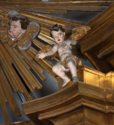 Zdjęcie nr 6: Nastawa architektoniczna, jednokondygnacyjna z glorią, jednoosiowa z bramkami, ustawiona na dwustrefowym cokole, na planie półowalu. Ołtarz kamienny, prostopadłościenny, z wcięciami na bocznych ściankach, zakończony profilowanym gzymsem; mensa kamienna. Na ściance frontowej namalowana scena Ostatniej Wieczerzy. Na ołtarzu ustawione drewniane tabernakulum obite blachą, w formie prostopadłościanu o wypukłych bokach, w narożach ujętego pilastrami o kanelowanych trzonach, dźwigającymi profilowany gzyms. Drzwiczki dwuskrzydłowe, w formie stojącego prostokąta zamkniętego łukiem półkolistym nadwieszonym, ujęty ramą z przedstawieniem baranka stojącego na ołtarzu, z którego piersi wypływa krew do kielicha; w górnej części monogram IHS. Nastawa ujęta dwiema parami filarów ustawionych pod kątem, o kanelowanych trzonach, dekorowanych kampanulami, podtrzymujących pełne belkowanie wyłamane na ich osi, z silnie wysuniętym gzymsem. Fryz zdobiony ornamentem roślinnym, w jego centrum kartusz z napisem „SANCTVS”. Na belkowaniu fragmenty zdwojonego, półkolistego przyczółka, z siedzącymi puttami. Pole główne wypełnione wnęką w formie stojącego prostokąta zamkniętego łukiem półkolistym nadwieszonym, ujęta profilowaną ramą, z obrazem Narodzenia Najświętszej Marii Panny. W przyłuczach dekoracja roślinna. Nastawa flankowana uszami utworzonymi z karbowanej wstęgi i ornamentu roślinnego. W miejscu zwieńczenia gołębica Ducha Świętego w otoku z obłoków i uskrzydlonych główek anielskich, w glorii promienistej. Bramki z drzwiczkami w formie stojącego prostokąta o wklęsłych górnych narożach ze ślimacznicami, ujęte grubą opaską, zwieńczone kluczem z herbem Uniwersytetu Jagiellońskiego oraz fragmentem profilowanego gzymsu, który stanowi podstawę dla figur św. Anny i św. Joachima. Herb lewej bramki z syglami „M[atthaeus] F[ranciscus]  K[alewski] / D[ecanus] S[antae] A[nnae] / C[uratus] Z[elenensis]”, herb prawej bramki z inskrypcją „A[NNO] D[OMINI] / 17/28”. Struktura w całości złocona, detale glorii srebrzone. Na odwrocie nastawy inskrypcja: „ODNOWIONO OŁTARZ ZA STARANIEM / KS(IĘDZA) JANA MICHALIKA. R(OKU) 1902.”