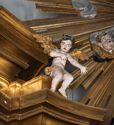 Zdjęcie nr 27: Nastawa architektoniczna, jednokondygnacyjna z glorią, jednoosiowa z bramkami, ustawiona na dwustrefowym cokole, na planie półowalu. Ołtarz kamienny, prostopadłościenny, z wcięciami na bocznych ściankach, zakończony profilowanym gzymsem; mensa kamienna. Na ściance frontowej namalowana scena Ostatniej Wieczerzy. Na ołtarzu ustawione drewniane tabernakulum obite blachą, w formie prostopadłościanu o wypukłych bokach, w narożach ujętego pilastrami o kanelowanych trzonach, dźwigającymi profilowany gzyms. Drzwiczki dwuskrzydłowe, w formie stojącego prostokąta zamkniętego łukiem półkolistym nadwieszonym, ujęty ramą z przedstawieniem baranka stojącego na ołtarzu, z którego piersi wypływa krew do kielicha; w górnej części monogram IHS. Nastawa ujęta dwiema parami filarów ustawionych pod kątem, o kanelowanych trzonach, dekorowanych kampanulami, podtrzymujących pełne belkowanie wyłamane na ich osi, z silnie wysuniętym gzymsem. Fryz zdobiony ornamentem roślinnym, w jego centrum kartusz z napisem „SANCTVS”. Na belkowaniu fragmenty zdwojonego, półkolistego przyczółka, z siedzącymi puttami. Pole główne wypełnione wnęką w formie stojącego prostokąta zamkniętego łukiem półkolistym nadwieszonym, ujęta profilowaną ramą, z obrazem Narodzenia Najświętszej Marii Panny. W przyłuczach dekoracja roślinna. Nastawa flankowana uszami utworzonymi z karbowanej wstęgi i ornamentu roślinnego. W miejscu zwieńczenia gołębica Ducha Świętego w otoku z obłoków i uskrzydlonych główek anielskich, w glorii promienistej. Bramki z drzwiczkami w formie stojącego prostokąta o wklęsłych górnych narożach ze ślimacznicami, ujęte grubą opaską, zwieńczone kluczem z herbem Uniwersytetu Jagiellońskiego oraz fragmentem profilowanego gzymsu, który stanowi podstawę dla figur św. Anny i św. Joachima. Herb lewej bramki z syglami „M[atthaeus] F[ranciscus]  K[alewski] / D[ecanus] S[antae] A[nnae] / C[uratus] Z[elenensis]”, herb prawej bramki z inskrypcją „A[NNO] D[OMINI] / 17/28”. Struktura w całości złocona, detale glorii srebrzone. Na odwrocie nastawy inskrypcja: „ODNOWIONO OŁTARZ ZA STARANIEM / KS(IĘDZA) JANA MICHALIKA. R(OKU) 1902.”