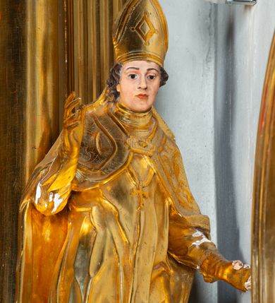 Zdjęcie nr 4: Nastawa architektoniczna, jednoosiowa, dwukondygnacyjna. Ołtarz prostopadłościenny, zwężający się ku dołowi, murowany, obłożony kamiennymi płytami, z krzyżem na froncie. 
Nastawa na niskim cokole, z wyodrębnionymi dwoma, ukośnie ustawionymi prostopadłościanami, z konsolami, dekorowanymi akantem i kampanulami. Pośrodku cokołu wyodrębniony postument dekorowany płyciną z akantem. Kondygnacja flankowana dwiema parami pilastrów o kanelowanych trzonach oraz ustawioną przed nimi parą kolumn o kapitelach kompozytowych. Podpory dźwigają pełne belkowanie, wyłamane na ich osi, z silnie wysuniętym gzymsem, z przerwanym architrawem i fryzem nad polem środkowym. Na belkowaniu fragmenty przerwanego, wolutowego przyczółka, zwrócone pod kątem, do wewnątrz. W polu środkowym wnęka w formie stojącego prostokąta zamkniętego łukiem półkolistym, ujęta profilowaną ramą dekorowaną na bokach kwiatami, zwieńczoną muszlą. We wnęce obraz św. Józefa z Dzieciątkiem. Poniżej wnęki płaskorzeźbione narzędzia stolarskie (piła, siekiera, kątownik, obcęgi) i stylizowany monogram świętego. Na konsolach, po bokach nastawy ustawione figury św. Wojciecha i św. Stanisława. Retabulum flankowane uszami utworzonymi z karbowanej wstęgi i ornamentu roślinnego. Druga kondygnacja węższa, ujęta ustawionymi pod kątem pilastrami, o trzonach dekorowanych kampanulami. Pilastry podtrzymują gzyms wyłamany na ich osi, nad polem przyjmujący kształt łuku półkolistego nadwieszonego. Na nim ustawione trzy wazony z kwiatami. W polu obraz św. Jana Kantego w formie stojącego owalu, ujęty ramą, dekorowaną ornamentem roślinnym. Struktura niemal w całości złocona, elementy cokołu i fryzu polichromowane w kolorze czerwonym, ornamentyka złocona. 
