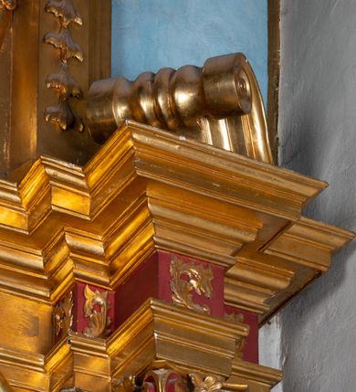 Zdjęcie nr 14: Nastawa architektoniczna, jednoosiowa, dwukondygnacyjna. Ołtarz prostopadłościenny, zwężający się ku dołowi, murowany, obłożony kamiennymi płytami, z krzyżem na froncie. 
Nastawa na niskim cokole, z wyodrębnionymi dwoma, ukośnie ustawionymi prostopadłościanami, z konsolami, dekorowanymi akantem i kampanulami. Pośrodku cokołu wyodrębniony postument dekorowany płyciną z akantem. Kondygnacja flankowana dwiema parami pilastrów o kanelowanych trzonach oraz ustawioną przed nimi parą kolumn o kapitelach kompozytowych. Podpory dźwigają pełne belkowanie, wyłamane na ich osi, z silnie wysuniętym gzymsem, z przerwanym architrawem i fryzem nad polem środkowym. Na belkowaniu fragmenty przerwanego, wolutowego przyczółka, zwrócone pod kątem, do wewnątrz. W polu środkowym wnęka w formie stojącego prostokąta zamkniętego łukiem półkolistym, ujęta profilowaną ramą dekorowaną na bokach kwiatami, zwieńczoną muszlą. We wnęce obraz św. Józefa z Dzieciątkiem. Poniżej wnęki płaskorzeźbione narzędzia stolarskie (piła, siekiera, kątownik, obcęgi) i stylizowany monogram świętego. Na konsolach, po bokach nastawy ustawione figury św. Wojciecha i św. Stanisława. Retabulum flankowane uszami utworzonymi z karbowanej wstęgi i ornamentu roślinnego. Druga kondygnacja węższa, ujęta ustawionymi pod kątem pilastrami, o trzonach dekorowanych kampanulami. Pilastry podtrzymują gzyms wyłamany na ich osi, nad polem przyjmujący kształt łuku półkolistego nadwieszonego. Na nim ustawione trzy wazony z kwiatami. W polu obraz św. Jana Kantego w formie stojącego owalu, ujęty ramą, dekorowaną ornamentem roślinnym. Struktura niemal w całości złocona, elementy cokołu i fryzu polichromowane w kolorze czerwonym, ornamentyka złocona. 
