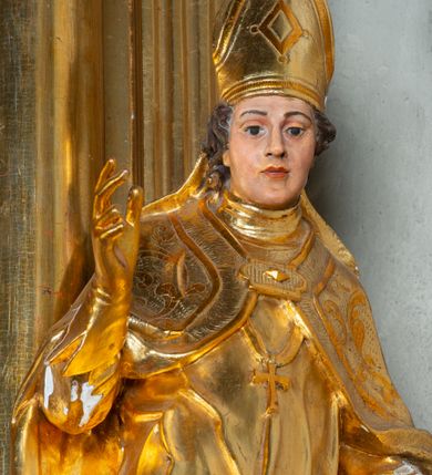 Zdjęcie nr 17: Nastawa architektoniczna, jednoosiowa, dwukondygnacyjna. Ołtarz prostopadłościenny, zwężający się ku dołowi, murowany, obłożony kamiennymi płytami, z krzyżem na froncie. 
Nastawa na niskim cokole, z wyodrębnionymi dwoma, ukośnie ustawionymi prostopadłościanami, z konsolami, dekorowanymi akantem i kampanulami. Pośrodku cokołu wyodrębniony postument dekorowany płyciną z akantem. Kondygnacja flankowana dwiema parami pilastrów o kanelowanych trzonach oraz ustawioną przed nimi parą kolumn o kapitelach kompozytowych. Podpory dźwigają pełne belkowanie, wyłamane na ich osi, z silnie wysuniętym gzymsem, z przerwanym architrawem i fryzem nad polem środkowym. Na belkowaniu fragmenty przerwanego, wolutowego przyczółka, zwrócone pod kątem, do wewnątrz. W polu środkowym wnęka w formie stojącego prostokąta zamkniętego łukiem półkolistym, ujęta profilowaną ramą dekorowaną na bokach kwiatami, zwieńczoną muszlą. We wnęce obraz św. Józefa z Dzieciątkiem. Poniżej wnęki płaskorzeźbione narzędzia stolarskie (piła, siekiera, kątownik, obcęgi) i stylizowany monogram świętego. Na konsolach, po bokach nastawy ustawione figury św. Wojciecha i św. Stanisława. Retabulum flankowane uszami utworzonymi z karbowanej wstęgi i ornamentu roślinnego. Druga kondygnacja węższa, ujęta ustawionymi pod kątem pilastrami, o trzonach dekorowanych kampanulami. Pilastry podtrzymują gzyms wyłamany na ich osi, nad polem przyjmujący kształt łuku półkolistego nadwieszonego. Na nim ustawione trzy wazony z kwiatami. W polu obraz św. Jana Kantego w formie stojącego owalu, ujęty ramą, dekorowaną ornamentem roślinnym. Struktura niemal w całości złocona, elementy cokołu i fryzu polichromowane w kolorze czerwonym, ornamentyka złocona. 
