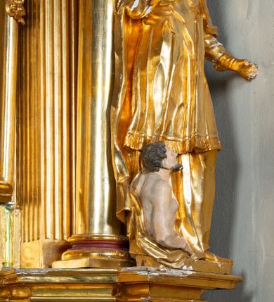 Zdjęcie nr 21: Nastawa architektoniczna, jednoosiowa, dwukondygnacyjna. Ołtarz prostopadłościenny, zwężający się ku dołowi, murowany, obłożony kamiennymi płytami, z krzyżem na froncie. 
Nastawa na niskim cokole, z wyodrębnionymi dwoma, ukośnie ustawionymi prostopadłościanami, z konsolami, dekorowanymi akantem i kampanulami. Pośrodku cokołu wyodrębniony postument dekorowany płyciną z akantem. Kondygnacja flankowana dwiema parami pilastrów o kanelowanych trzonach oraz ustawioną przed nimi parą kolumn o kapitelach kompozytowych. Podpory dźwigają pełne belkowanie, wyłamane na ich osi, z silnie wysuniętym gzymsem, z przerwanym architrawem i fryzem nad polem środkowym. Na belkowaniu fragmenty przerwanego, wolutowego przyczółka, zwrócone pod kątem, do wewnątrz. W polu środkowym wnęka w formie stojącego prostokąta zamkniętego łukiem półkolistym, ujęta profilowaną ramą dekorowaną na bokach kwiatami, zwieńczoną muszlą. We wnęce obraz św. Józefa z Dzieciątkiem. Poniżej wnęki płaskorzeźbione narzędzia stolarskie (piła, siekiera, kątownik, obcęgi) i stylizowany monogram świętego. Na konsolach, po bokach nastawy ustawione figury św. Wojciecha i św. Stanisława. Retabulum flankowane uszami utworzonymi z karbowanej wstęgi i ornamentu roślinnego. Druga kondygnacja węższa, ujęta ustawionymi pod kątem pilastrami, o trzonach dekorowanych kampanulami. Pilastry podtrzymują gzyms wyłamany na ich osi, nad polem przyjmujący kształt łuku półkolistego nadwieszonego. Na nim ustawione trzy wazony z kwiatami. W polu obraz św. Jana Kantego w formie stojącego owalu, ujęty ramą, dekorowaną ornamentem roślinnym. Struktura niemal w całości złocona, elementy cokołu i fryzu polichromowane w kolorze czerwonym, ornamentyka złocona. 
