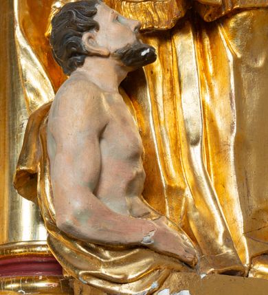 Zdjęcie nr 22: Nastawa architektoniczna, jednoosiowa, dwukondygnacyjna. Ołtarz prostopadłościenny, zwężający się ku dołowi, murowany, obłożony kamiennymi płytami, z krzyżem na froncie. 
Nastawa na niskim cokole, z wyodrębnionymi dwoma, ukośnie ustawionymi prostopadłościanami, z konsolami, dekorowanymi akantem i kampanulami. Pośrodku cokołu wyodrębniony postument dekorowany płyciną z akantem. Kondygnacja flankowana dwiema parami pilastrów o kanelowanych trzonach oraz ustawioną przed nimi parą kolumn o kapitelach kompozytowych. Podpory dźwigają pełne belkowanie, wyłamane na ich osi, z silnie wysuniętym gzymsem, z przerwanym architrawem i fryzem nad polem środkowym. Na belkowaniu fragmenty przerwanego, wolutowego przyczółka, zwrócone pod kątem, do wewnątrz. W polu środkowym wnęka w formie stojącego prostokąta zamkniętego łukiem półkolistym, ujęta profilowaną ramą dekorowaną na bokach kwiatami, zwieńczoną muszlą. We wnęce obraz św. Józefa z Dzieciątkiem. Poniżej wnęki płaskorzeźbione narzędzia stolarskie (piła, siekiera, kątownik, obcęgi) i stylizowany monogram świętego. Na konsolach, po bokach nastawy ustawione figury św. Wojciecha i św. Stanisława. Retabulum flankowane uszami utworzonymi z karbowanej wstęgi i ornamentu roślinnego. Druga kondygnacja węższa, ujęta ustawionymi pod kątem pilastrami, o trzonach dekorowanych kampanulami. Pilastry podtrzymują gzyms wyłamany na ich osi, nad polem przyjmujący kształt łuku półkolistego nadwieszonego. Na nim ustawione trzy wazony z kwiatami. W polu obraz św. Jana Kantego w formie stojącego owalu, ujęty ramą, dekorowaną ornamentem roślinnym. Struktura niemal w całości złocona, elementy cokołu i fryzu polichromowane w kolorze czerwonym, ornamentyka złocona. 
