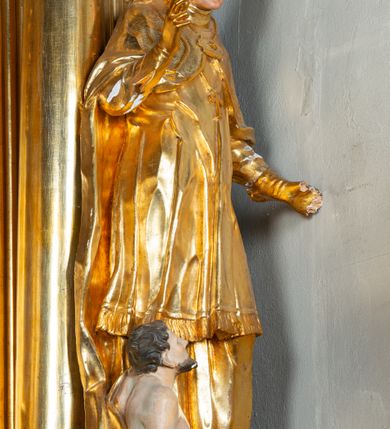 Zdjęcie nr 27: Nastawa architektoniczna, jednoosiowa, dwukondygnacyjna. Ołtarz prostopadłościenny, zwężający się ku dołowi, murowany, obłożony kamiennymi płytami, z krzyżem na froncie. 
Nastawa na niskim cokole, z wyodrębnionymi dwoma, ukośnie ustawionymi prostopadłościanami, z konsolami, dekorowanymi akantem i kampanulami. Pośrodku cokołu wyodrębniony postument dekorowany płyciną z akantem. Kondygnacja flankowana dwiema parami pilastrów o kanelowanych trzonach oraz ustawioną przed nimi parą kolumn o kapitelach kompozytowych. Podpory dźwigają pełne belkowanie, wyłamane na ich osi, z silnie wysuniętym gzymsem, z przerwanym architrawem i fryzem nad polem środkowym. Na belkowaniu fragmenty przerwanego, wolutowego przyczółka, zwrócone pod kątem, do wewnątrz. W polu środkowym wnęka w formie stojącego prostokąta zamkniętego łukiem półkolistym, ujęta profilowaną ramą dekorowaną na bokach kwiatami, zwieńczoną muszlą. We wnęce obraz św. Józefa z Dzieciątkiem. Poniżej wnęki płaskorzeźbione narzędzia stolarskie (piła, siekiera, kątownik, obcęgi) i stylizowany monogram świętego. Na konsolach, po bokach nastawy ustawione figury św. Wojciecha i św. Stanisława. Retabulum flankowane uszami utworzonymi z karbowanej wstęgi i ornamentu roślinnego. Druga kondygnacja węższa, ujęta ustawionymi pod kątem pilastrami, o trzonach dekorowanych kampanulami. Pilastry podtrzymują gzyms wyłamany na ich osi, nad polem przyjmujący kształt łuku półkolistego nadwieszonego. Na nim ustawione trzy wazony z kwiatami. W polu obraz św. Jana Kantego w formie stojącego owalu, ujęty ramą, dekorowaną ornamentem roślinnym. Struktura niemal w całości złocona, elementy cokołu i fryzu polichromowane w kolorze czerwonym, ornamentyka złocona. 
