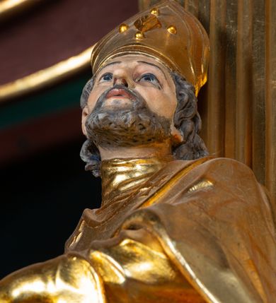 Zdjęcie nr 28: Nastawa architektoniczna, jednoosiowa, dwukondygnacyjna. Ołtarz prostopadłościenny, zwężający się ku dołowi, murowany, obłożony kamiennymi płytami, z krzyżem na froncie. 
Nastawa na niskim cokole, z wyodrębnionymi dwoma, ukośnie ustawionymi prostopadłościanami, z konsolami, dekorowanymi akantem i kampanulami. Pośrodku cokołu wyodrębniony postument dekorowany płyciną z akantem. Kondygnacja flankowana dwiema parami pilastrów o kanelowanych trzonach oraz ustawioną przed nimi parą kolumn o kapitelach kompozytowych. Podpory dźwigają pełne belkowanie, wyłamane na ich osi, z silnie wysuniętym gzymsem, z przerwanym architrawem i fryzem nad polem środkowym. Na belkowaniu fragmenty przerwanego, wolutowego przyczółka, zwrócone pod kątem, do wewnątrz. W polu środkowym wnęka w formie stojącego prostokąta zamkniętego łukiem półkolistym, ujęta profilowaną ramą dekorowaną na bokach kwiatami, zwieńczoną muszlą. We wnęce obraz św. Józefa z Dzieciątkiem. Poniżej wnęki płaskorzeźbione narzędzia stolarskie (piła, siekiera, kątownik, obcęgi) i stylizowany monogram świętego. Na konsolach, po bokach nastawy ustawione figury św. Wojciecha i św. Stanisława. Retabulum flankowane uszami utworzonymi z karbowanej wstęgi i ornamentu roślinnego. Druga kondygnacja węższa, ujęta ustawionymi pod kątem pilastrami, o trzonach dekorowanych kampanulami. Pilastry podtrzymują gzyms wyłamany na ich osi, nad polem przyjmujący kształt łuku półkolistego nadwieszonego. Na nim ustawione trzy wazony z kwiatami. W polu obraz św. Jana Kantego w formie stojącego owalu, ujęty ramą, dekorowaną ornamentem roślinnym. Struktura niemal w całości złocona, elementy cokołu i fryzu polichromowane w kolorze czerwonym, ornamentyka złocona. 
