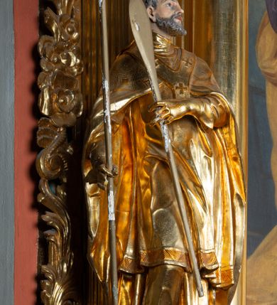 Zdjęcie nr 33: Nastawa architektoniczna, jednoosiowa, dwukondygnacyjna. Ołtarz prostopadłościenny, zwężający się ku dołowi, murowany, obłożony kamiennymi płytami, z krzyżem na froncie. 
Nastawa na niskim cokole, z wyodrębnionymi dwoma, ukośnie ustawionymi prostopadłościanami, z konsolami, dekorowanymi akantem i kampanulami. Pośrodku cokołu wyodrębniony postument dekorowany płyciną z akantem. Kondygnacja flankowana dwiema parami pilastrów o kanelowanych trzonach oraz ustawioną przed nimi parą kolumn o kapitelach kompozytowych. Podpory dźwigają pełne belkowanie, wyłamane na ich osi, z silnie wysuniętym gzymsem, z przerwanym architrawem i fryzem nad polem środkowym. Na belkowaniu fragmenty przerwanego, wolutowego przyczółka, zwrócone pod kątem, do wewnątrz. W polu środkowym wnęka w formie stojącego prostokąta zamkniętego łukiem półkolistym, ujęta profilowaną ramą dekorowaną na bokach kwiatami, zwieńczoną muszlą. We wnęce obraz św. Józefa z Dzieciątkiem. Poniżej wnęki płaskorzeźbione narzędzia stolarskie (piła, siekiera, kątownik, obcęgi) i stylizowany monogram świętego. Na konsolach, po bokach nastawy ustawione figury św. Wojciecha i św. Stanisława. Retabulum flankowane uszami utworzonymi z karbowanej wstęgi i ornamentu roślinnego. Druga kondygnacja węższa, ujęta ustawionymi pod kątem pilastrami, o trzonach dekorowanych kampanulami. Pilastry podtrzymują gzyms wyłamany na ich osi, nad polem przyjmujący kształt łuku półkolistego nadwieszonego. Na nim ustawione trzy wazony z kwiatami. W polu obraz św. Jana Kantego w formie stojącego owalu, ujęty ramą, dekorowaną ornamentem roślinnym. Struktura niemal w całości złocona, elementy cokołu i fryzu polichromowane w kolorze czerwonym, ornamentyka złocona. 
