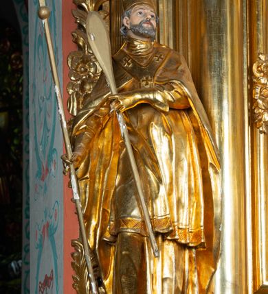 Zdjęcie nr 35: Nastawa architektoniczna, jednoosiowa, dwukondygnacyjna. Ołtarz prostopadłościenny, zwężający się ku dołowi, murowany, obłożony kamiennymi płytami, z krzyżem na froncie. 
Nastawa na niskim cokole, z wyodrębnionymi dwoma, ukośnie ustawionymi prostopadłościanami, z konsolami, dekorowanymi akantem i kampanulami. Pośrodku cokołu wyodrębniony postument dekorowany płyciną z akantem. Kondygnacja flankowana dwiema parami pilastrów o kanelowanych trzonach oraz ustawioną przed nimi parą kolumn o kapitelach kompozytowych. Podpory dźwigają pełne belkowanie, wyłamane na ich osi, z silnie wysuniętym gzymsem, z przerwanym architrawem i fryzem nad polem środkowym. Na belkowaniu fragmenty przerwanego, wolutowego przyczółka, zwrócone pod kątem, do wewnątrz. W polu środkowym wnęka w formie stojącego prostokąta zamkniętego łukiem półkolistym, ujęta profilowaną ramą dekorowaną na bokach kwiatami, zwieńczoną muszlą. We wnęce obraz św. Józefa z Dzieciątkiem. Poniżej wnęki płaskorzeźbione narzędzia stolarskie (piła, siekiera, kątownik, obcęgi) i stylizowany monogram świętego. Na konsolach, po bokach nastawy ustawione figury św. Wojciecha i św. Stanisława. Retabulum flankowane uszami utworzonymi z karbowanej wstęgi i ornamentu roślinnego. Druga kondygnacja węższa, ujęta ustawionymi pod kątem pilastrami, o trzonach dekorowanych kampanulami. Pilastry podtrzymują gzyms wyłamany na ich osi, nad polem przyjmujący kształt łuku półkolistego nadwieszonego. Na nim ustawione trzy wazony z kwiatami. W polu obraz św. Jana Kantego w formie stojącego owalu, ujęty ramą, dekorowaną ornamentem roślinnym. Struktura niemal w całości złocona, elementy cokołu i fryzu polichromowane w kolorze czerwonym, ornamentyka złocona. 
