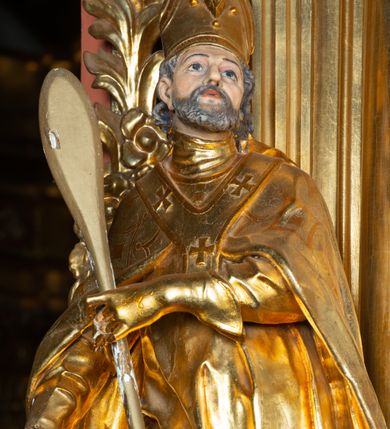 Zdjęcie nr 39: Nastawa architektoniczna, jednoosiowa, dwukondygnacyjna. Ołtarz prostopadłościenny, zwężający się ku dołowi, murowany, obłożony kamiennymi płytami, z krzyżem na froncie. 
Nastawa na niskim cokole, z wyodrębnionymi dwoma, ukośnie ustawionymi prostopadłościanami, z konsolami, dekorowanymi akantem i kampanulami. Pośrodku cokołu wyodrębniony postument dekorowany płyciną z akantem. Kondygnacja flankowana dwiema parami pilastrów o kanelowanych trzonach oraz ustawioną przed nimi parą kolumn o kapitelach kompozytowych. Podpory dźwigają pełne belkowanie, wyłamane na ich osi, z silnie wysuniętym gzymsem, z przerwanym architrawem i fryzem nad polem środkowym. Na belkowaniu fragmenty przerwanego, wolutowego przyczółka, zwrócone pod kątem, do wewnątrz. W polu środkowym wnęka w formie stojącego prostokąta zamkniętego łukiem półkolistym, ujęta profilowaną ramą dekorowaną na bokach kwiatami, zwieńczoną muszlą. We wnęce obraz św. Józefa z Dzieciątkiem. Poniżej wnęki płaskorzeźbione narzędzia stolarskie (piła, siekiera, kątownik, obcęgi) i stylizowany monogram świętego. Na konsolach, po bokach nastawy ustawione figury św. Wojciecha i św. Stanisława. Retabulum flankowane uszami utworzonymi z karbowanej wstęgi i ornamentu roślinnego. Druga kondygnacja węższa, ujęta ustawionymi pod kątem pilastrami, o trzonach dekorowanych kampanulami. Pilastry podtrzymują gzyms wyłamany na ich osi, nad polem przyjmujący kształt łuku półkolistego nadwieszonego. Na nim ustawione trzy wazony z kwiatami. W polu obraz św. Jana Kantego w formie stojącego owalu, ujęty ramą, dekorowaną ornamentem roślinnym. Struktura niemal w całości złocona, elementy cokołu i fryzu polichromowane w kolorze czerwonym, ornamentyka złocona. 
