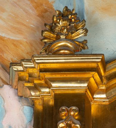 Zdjęcie nr 40: Nastawa architektoniczna, jednoosiowa, dwukondygnacyjna. Ołtarz prostopadłościenny, zwężający się ku dołowi, murowany, obłożony kamiennymi płytami, z krzyżem na froncie. 
Nastawa na niskim cokole, z wyodrębnionymi dwoma, ukośnie ustawionymi prostopadłościanami, z konsolami, dekorowanymi akantem i kampanulami. Pośrodku cokołu wyodrębniony postument dekorowany płyciną z akantem. Kondygnacja flankowana dwiema parami pilastrów o kanelowanych trzonach oraz ustawioną przed nimi parą kolumn o kapitelach kompozytowych. Podpory dźwigają pełne belkowanie, wyłamane na ich osi, z silnie wysuniętym gzymsem, z przerwanym architrawem i fryzem nad polem środkowym. Na belkowaniu fragmenty przerwanego, wolutowego przyczółka, zwrócone pod kątem, do wewnątrz. W polu środkowym wnęka w formie stojącego prostokąta zamkniętego łukiem półkolistym, ujęta profilowaną ramą dekorowaną na bokach kwiatami, zwieńczoną muszlą. We wnęce obraz św. Józefa z Dzieciątkiem. Poniżej wnęki płaskorzeźbione narzędzia stolarskie (piła, siekiera, kątownik, obcęgi) i stylizowany monogram świętego. Na konsolach, po bokach nastawy ustawione figury św. Wojciecha i św. Stanisława. Retabulum flankowane uszami utworzonymi z karbowanej wstęgi i ornamentu roślinnego. Druga kondygnacja węższa, ujęta ustawionymi pod kątem pilastrami, o trzonach dekorowanych kampanulami. Pilastry podtrzymują gzyms wyłamany na ich osi, nad polem przyjmujący kształt łuku półkolistego nadwieszonego. Na nim ustawione trzy wazony z kwiatami. W polu obraz św. Jana Kantego w formie stojącego owalu, ujęty ramą, dekorowaną ornamentem roślinnym. Struktura niemal w całości złocona, elementy cokołu i fryzu polichromowane w kolorze czerwonym, ornamentyka złocona. 
