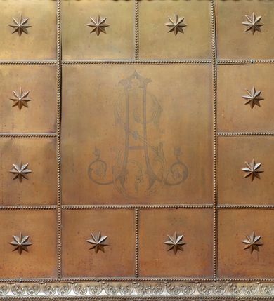 Zdjęcie nr 52: Nastawa architektoniczna, jednoosiowa, dwukondygnacyjna. Ołtarz murowany, prostopadłościenny, obity metalową blachą, zdobioną trybowaną kratownicą i gwiazdkami. Wewnątrz grób Chrystusa ze współczesną rzeźbą. Nastawa na niskim cokole, z wyodrębnionymi dwoma, ukośnie ustawionymi prostopadłościanami, z konsolami, dekorowanymi akantem i kampanulami. Pośrodku cokołu zamontowany obraz św. Faustyny w kształcie wieloboku. Kondygnacja flankowana dwiema parami pilastrów o kanelowanych trzonach oraz ustawioną przed nimi parą kolumn o kapitelach kompozytowych. Podpory dźwigają pełne belkowanie, wyłamane na ich osi, z silnie wysuniętym gzymsem, z przerwanym architrawem i fryzem nad polem środkowym. Na belkowaniu fragmenty przerwanego, wolutowego przyczółka, zwrócone pod kątem, do wewnątrz. W polu środkowym wnęka w formie stojącego prostokąta zamkniętego łukiem półkolistym, ujęta profilowaną ramą dekorowaną na bokach kwiatami, zwieńczoną muszlą. We wnęce obraz „Jezu Ufam Tobie”. Na konsolach, po bokach nastawy ustawione figury św. Kazimierza i św. Jana Kantego. Nastawa flankowana uszami utworzonymi z karbowanej wstęgi i ornamentu roślinnego. Druga kondygnacja węższa, flankowana ustawionymi pod kątem pilastrami, o trzonach dekorowanych kampanulami. Pilastry podtrzymują gzyms wyłamany na ich osi, nad polem przyjmujący kształt łuku półkolistego nadwieszonego. Na nim ustawione dwa wazony z kwiatami i bukiet kwiatów. W polu obraz św. Joachima w formie stojącego owalu, ujęty ramą, dekorowaną ornamentem roślinnym. Struktura niemal w całości złocona, elementy cokołu i fryzu polichromowane w kolorze czerwonym, ornamentyka złocona. 


