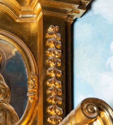 Zdjęcie nr 7: Nastawa architektoniczna, jednoosiowa, dwukondygnacyjna. Ołtarz murowany, prostopadłościenny, obity metalową blachą, zdobioną trybowaną kratownicą i gwiazdkami. Wewnątrz grób Chrystusa ze współczesną rzeźbą. Nastawa na niskim cokole, z wyodrębnionymi dwoma, ukośnie ustawionymi prostopadłościanami, z konsolami, dekorowanymi akantem i kampanulami. Pośrodku cokołu zamontowany obraz św. Faustyny w kształcie wieloboku. Kondygnacja flankowana dwiema parami pilastrów o kanelowanych trzonach oraz ustawioną przed nimi parą kolumn o kapitelach kompozytowych. Podpory dźwigają pełne belkowanie, wyłamane na ich osi, z silnie wysuniętym gzymsem, z przerwanym architrawem i fryzem nad polem środkowym. Na belkowaniu fragmenty przerwanego, wolutowego przyczółka, zwrócone pod kątem, do wewnątrz. W polu środkowym wnęka w formie stojącego prostokąta zamkniętego łukiem półkolistym, ujęta profilowaną ramą dekorowaną na bokach kwiatami, zwieńczoną muszlą. We wnęce obraz „Jezu Ufam Tobie”. Na konsolach, po bokach nastawy ustawione figury św. Kazimierza i św. Jana Kantego. Nastawa flankowana uszami utworzonymi z karbowanej wstęgi i ornamentu roślinnego. Druga kondygnacja węższa, flankowana ustawionymi pod kątem pilastrami, o trzonach dekorowanych kampanulami. Pilastry podtrzymują gzyms wyłamany na ich osi, nad polem przyjmujący kształt łuku półkolistego nadwieszonego. Na nim ustawione dwa wazony z kwiatami i bukiet kwiatów. W polu obraz św. Joachima w formie stojącego owalu, ujęty ramą, dekorowaną ornamentem roślinnym. Struktura niemal w całości złocona, elementy cokołu i fryzu polichromowane w kolorze czerwonym, ornamentyka złocona. 


