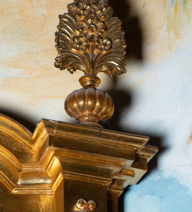 Zdjęcie nr 15: Nastawa architektoniczna, jednoosiowa, dwukondygnacyjna. Ołtarz murowany, prostopadłościenny, obity metalową blachą, zdobioną trybowaną kratownicą i gwiazdkami. Wewnątrz grób Chrystusa ze współczesną rzeźbą. Nastawa na niskim cokole, z wyodrębnionymi dwoma, ukośnie ustawionymi prostopadłościanami, z konsolami, dekorowanymi akantem i kampanulami. Pośrodku cokołu zamontowany obraz św. Faustyny w kształcie wieloboku. Kondygnacja flankowana dwiema parami pilastrów o kanelowanych trzonach oraz ustawioną przed nimi parą kolumn o kapitelach kompozytowych. Podpory dźwigają pełne belkowanie, wyłamane na ich osi, z silnie wysuniętym gzymsem, z przerwanym architrawem i fryzem nad polem środkowym. Na belkowaniu fragmenty przerwanego, wolutowego przyczółka, zwrócone pod kątem, do wewnątrz. W polu środkowym wnęka w formie stojącego prostokąta zamkniętego łukiem półkolistym, ujęta profilowaną ramą dekorowaną na bokach kwiatami, zwieńczoną muszlą. We wnęce obraz „Jezu Ufam Tobie”. Na konsolach, po bokach nastawy ustawione figury św. Kazimierza i św. Jana Kantego. Nastawa flankowana uszami utworzonymi z karbowanej wstęgi i ornamentu roślinnego. Druga kondygnacja węższa, flankowana ustawionymi pod kątem pilastrami, o trzonach dekorowanych kampanulami. Pilastry podtrzymują gzyms wyłamany na ich osi, nad polem przyjmujący kształt łuku półkolistego nadwieszonego. Na nim ustawione dwa wazony z kwiatami i bukiet kwiatów. W polu obraz św. Joachima w formie stojącego owalu, ujęty ramą, dekorowaną ornamentem roślinnym. Struktura niemal w całości złocona, elementy cokołu i fryzu polichromowane w kolorze czerwonym, ornamentyka złocona. 


