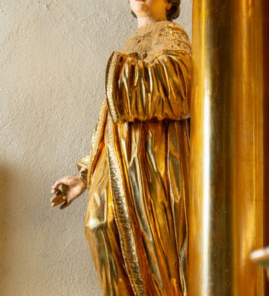 Zdjęcie nr 25: Nastawa architektoniczna, jednoosiowa, dwukondygnacyjna. Ołtarz murowany, prostopadłościenny, obity metalową blachą, zdobioną trybowaną kratownicą i gwiazdkami. Wewnątrz grób Chrystusa ze współczesną rzeźbą. Nastawa na niskim cokole, z wyodrębnionymi dwoma, ukośnie ustawionymi prostopadłościanami, z konsolami, dekorowanymi akantem i kampanulami. Pośrodku cokołu zamontowany obraz św. Faustyny w kształcie wieloboku. Kondygnacja flankowana dwiema parami pilastrów o kanelowanych trzonach oraz ustawioną przed nimi parą kolumn o kapitelach kompozytowych. Podpory dźwigają pełne belkowanie, wyłamane na ich osi, z silnie wysuniętym gzymsem, z przerwanym architrawem i fryzem nad polem środkowym. Na belkowaniu fragmenty przerwanego, wolutowego przyczółka, zwrócone pod kątem, do wewnątrz. W polu środkowym wnęka w formie stojącego prostokąta zamkniętego łukiem półkolistym, ujęta profilowaną ramą dekorowaną na bokach kwiatami, zwieńczoną muszlą. We wnęce obraz „Jezu Ufam Tobie”. Na konsolach, po bokach nastawy ustawione figury św. Kazimierza i św. Jana Kantego. Nastawa flankowana uszami utworzonymi z karbowanej wstęgi i ornamentu roślinnego. Druga kondygnacja węższa, flankowana ustawionymi pod kątem pilastrami, o trzonach dekorowanych kampanulami. Pilastry podtrzymują gzyms wyłamany na ich osi, nad polem przyjmujący kształt łuku półkolistego nadwieszonego. Na nim ustawione dwa wazony z kwiatami i bukiet kwiatów. W polu obraz św. Joachima w formie stojącego owalu, ujęty ramą, dekorowaną ornamentem roślinnym. Struktura niemal w całości złocona, elementy cokołu i fryzu polichromowane w kolorze czerwonym, ornamentyka złocona. 


