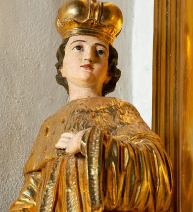 Zdjęcie nr 26: Nastawa architektoniczna, jednoosiowa, dwukondygnacyjna. Ołtarz murowany, prostopadłościenny, obity metalową blachą, zdobioną trybowaną kratownicą i gwiazdkami. Wewnątrz grób Chrystusa ze współczesną rzeźbą. Nastawa na niskim cokole, z wyodrębnionymi dwoma, ukośnie ustawionymi prostopadłościanami, z konsolami, dekorowanymi akantem i kampanulami. Pośrodku cokołu zamontowany obraz św. Faustyny w kształcie wieloboku. Kondygnacja flankowana dwiema parami pilastrów o kanelowanych trzonach oraz ustawioną przed nimi parą kolumn o kapitelach kompozytowych. Podpory dźwigają pełne belkowanie, wyłamane na ich osi, z silnie wysuniętym gzymsem, z przerwanym architrawem i fryzem nad polem środkowym. Na belkowaniu fragmenty przerwanego, wolutowego przyczółka, zwrócone pod kątem, do wewnątrz. W polu środkowym wnęka w formie stojącego prostokąta zamkniętego łukiem półkolistym, ujęta profilowaną ramą dekorowaną na bokach kwiatami, zwieńczoną muszlą. We wnęce obraz „Jezu Ufam Tobie”. Na konsolach, po bokach nastawy ustawione figury św. Kazimierza i św. Jana Kantego. Nastawa flankowana uszami utworzonymi z karbowanej wstęgi i ornamentu roślinnego. Druga kondygnacja węższa, flankowana ustawionymi pod kątem pilastrami, o trzonach dekorowanych kampanulami. Pilastry podtrzymują gzyms wyłamany na ich osi, nad polem przyjmujący kształt łuku półkolistego nadwieszonego. Na nim ustawione dwa wazony z kwiatami i bukiet kwiatów. W polu obraz św. Joachima w formie stojącego owalu, ujęty ramą, dekorowaną ornamentem roślinnym. Struktura niemal w całości złocona, elementy cokołu i fryzu polichromowane w kolorze czerwonym, ornamentyka złocona. 


