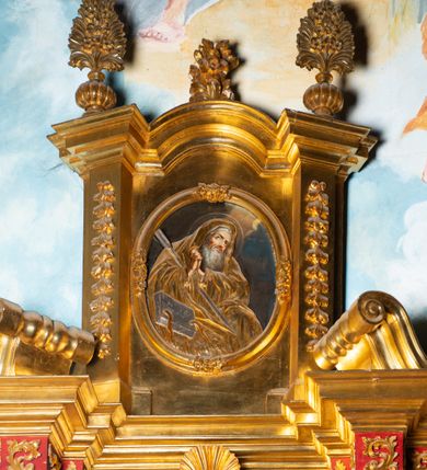 Zdjęcie nr 44: Nastawa architektoniczna, jednoosiowa, dwukondygnacyjna. Ołtarz murowany, prostopadłościenny, obity metalową blachą, zdobioną trybowaną kratownicą i gwiazdkami. Wewnątrz grób Chrystusa ze współczesną rzeźbą. Nastawa na niskim cokole, z wyodrębnionymi dwoma, ukośnie ustawionymi prostopadłościanami, z konsolami, dekorowanymi akantem i kampanulami. Pośrodku cokołu zamontowany obraz św. Faustyny w kształcie wieloboku. Kondygnacja flankowana dwiema parami pilastrów o kanelowanych trzonach oraz ustawioną przed nimi parą kolumn o kapitelach kompozytowych. Podpory dźwigają pełne belkowanie, wyłamane na ich osi, z silnie wysuniętym gzymsem, z przerwanym architrawem i fryzem nad polem środkowym. Na belkowaniu fragmenty przerwanego, wolutowego przyczółka, zwrócone pod kątem, do wewnątrz. W polu środkowym wnęka w formie stojącego prostokąta zamkniętego łukiem półkolistym, ujęta profilowaną ramą dekorowaną na bokach kwiatami, zwieńczoną muszlą. We wnęce obraz „Jezu Ufam Tobie”. Na konsolach, po bokach nastawy ustawione figury św. Kazimierza i św. Jana Kantego. Nastawa flankowana uszami utworzonymi z karbowanej wstęgi i ornamentu roślinnego. Druga kondygnacja węższa, flankowana ustawionymi pod kątem pilastrami, o trzonach dekorowanych kampanulami. Pilastry podtrzymują gzyms wyłamany na ich osi, nad polem przyjmujący kształt łuku półkolistego nadwieszonego. Na nim ustawione dwa wazony z kwiatami i bukiet kwiatów. W polu obraz św. Joachima w formie stojącego owalu, ujęty ramą, dekorowaną ornamentem roślinnym. Struktura niemal w całości złocona, elementy cokołu i fryzu polichromowane w kolorze czerwonym, ornamentyka złocona. 


