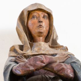 Zdjęcie nr 1: Rzeźba pełna, ustawiona na niewielkiej, owalnej podstawie. Maria przedstawiona frontalnie, w pozycji stojącej z rękami skrzyżowanymi na wysokości piersi. Matka Chrystusa została przedstawiona jako szczupła kobieta o owalnej twarzy o zasmuconym wyrazie. Wyraźnie zaznaczone łuki brwiowe, długi prosty nos i niewielkie usta. Oczy skierowane przed siebie. Dłonie o długich i szczupłych palcach. Maria ubrana jest w fioletową suknię z długimi rękawami oraz obszerny, ciemnogranatowy płaszcz szczelnie otulający ciało i tworzący głęboko łamane, ostre fałdy. Na głowie Marii biała chusta oraz podwika. Figura w pełni polichromowana.