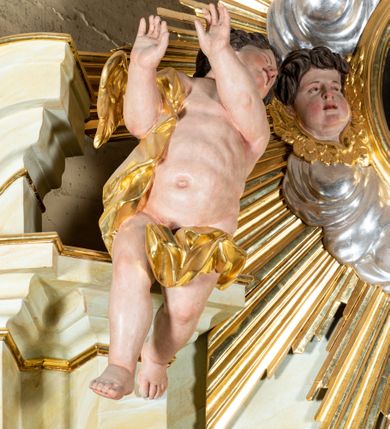 Zdjęcie nr 14: Ołtarz architektoniczny, jednokondygnacyjny, jednoosiowy ze zwieńczeniem i drewnianą, sarkofagową mensą. Na mensie ołtarza kremowe tabernakulum w formie prostopadłościennej szafki, ujęte parą jońskich, złoconych półkolumienek, stojących na profilowanym  cokoliku, wspierających belkowanie przechodzące nad polem centralnym w łuk. Drzwiczki w kształcie stojącego prostokąta zamkniętego łukiem pełnym zdobione płaskorzeźbionym motywem kielicha z hostią w glorii. Retabulum ołtarzowe na cokole, ujęte parą kolumn kompozytowych o spiralnie skręconych trzonach.  Podpory wspierają wyłamujące się ponad nimi oraz między nimi belkowanie o wysuniętym gzymsie, podtrzymujące przerwane fragmenty przyczółka. Pole środkowe w formie wnęki w kształcie stojącego prostokąta zamkniętego łukiem nadwieszonym z obrazem św. Anny Samotrzeć. Ujmuje ją para figur ustawionych na wysokich, zdwojonych cokołach. Postać z lewej strony trzyma berło, postać z prawej jabłko królewskie.  Zwieńczenie w formie stojącego owalu ujętego skłębionymi obłokami i szeroką glorią promienistą. W polu przedstawienie Matki Boskiej ujęte główkami anielskimi i parą putt. 
 Pola cokołu dekorowane płycinami. Na trzonach kolumn retabulum spiralnie oplatająca je wić roślinna. Wewnętrzne fragmenty wyłamanego gzymsu podtrzymują konsole, pod którymi podwieszono bukiety kwiatów. Struktura ołtarza polichromowana z imitacją marmoryzacji w odcieniach białym i kremowym, tło głowic kolumn czerwone, dekoracje i profile złocone i srebrzone. 
