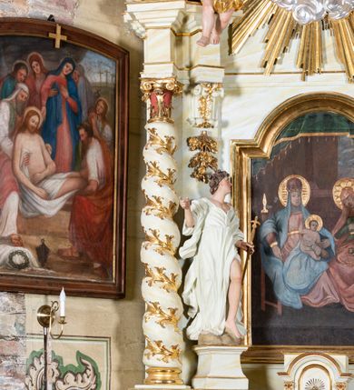 Zdjęcie nr 3: Ołtarz architektoniczny, jednokondygnacyjny, jednoosiowy ze zwieńczeniem i drewnianą, sarkofagową mensą. Na mensie ołtarza kremowe tabernakulum w formie prostopadłościennej szafki, ujęte parą jońskich, złoconych półkolumienek, stojących na profilowanym  cokoliku, wspierających belkowanie przechodzące nad polem centralnym w łuk. Drzwiczki w kształcie stojącego prostokąta zamkniętego łukiem pełnym zdobione płaskorzeźbionym motywem kielicha z hostią w glorii. Retabulum ołtarzowe na cokole, ujęte parą kolumn kompozytowych o spiralnie skręconych trzonach.  Podpory wspierają wyłamujące się ponad nimi oraz między nimi belkowanie o wysuniętym gzymsie, podtrzymujące przerwane fragmenty przyczółka. Pole środkowe w formie wnęki w kształcie stojącego prostokąta zamkniętego łukiem nadwieszonym z obrazem św. Anny Samotrzeć. Ujmuje ją para figur ustawionych na wysokich, zdwojonych cokołach. Postać z lewej strony trzyma berło, postać z prawej jabłko królewskie.  Zwieńczenie w formie stojącego owalu ujętego skłębionymi obłokami i szeroką glorią promienistą. W polu przedstawienie Matki Boskiej ujęte główkami anielskimi i parą putt. 
 Pola cokołu dekorowane płycinami. Na trzonach kolumn retabulum spiralnie oplatająca je wić roślinna. Wewnętrzne fragmenty wyłamanego gzymsu podtrzymują konsole, pod którymi podwieszono bukiety kwiatów. Struktura ołtarza polichromowana z imitacją marmoryzacji w odcieniach białym i kremowym, tło głowic kolumn czerwone, dekoracje i profile złocone i srebrzone. 
