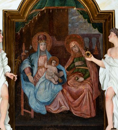 Zdjęcie nr 18: Ołtarz architektoniczny, jednokondygnacyjny, jednoosiowy ze zwieńczeniem i drewnianą, sarkofagową mensą. Na mensie ołtarza kremowe tabernakulum w formie prostopadłościennej szafki, ujęte parą jońskich, złoconych półkolumienek, stojących na profilowanym  cokoliku, wspierających belkowanie przechodzące nad polem centralnym w łuk. Drzwiczki w kształcie stojącego prostokąta zamkniętego łukiem pełnym zdobione płaskorzeźbionym motywem kielicha z hostią w glorii. Retabulum ołtarzowe na cokole, ujęte parą kolumn kompozytowych o spiralnie skręconych trzonach.  Podpory wspierają wyłamujące się ponad nimi oraz między nimi belkowanie o wysuniętym gzymsie, podtrzymujące przerwane fragmenty przyczółka. Pole środkowe w formie wnęki w kształcie stojącego prostokąta zamkniętego łukiem nadwieszonym z obrazem św. Anny Samotrzeć. Ujmuje ją para figur ustawionych na wysokich, zdwojonych cokołach. Postać z lewej strony trzyma berło, postać z prawej jabłko królewskie.  Zwieńczenie w formie stojącego owalu ujętego skłębionymi obłokami i szeroką glorią promienistą. W polu przedstawienie Matki Boskiej ujęte główkami anielskimi i parą putt. 
 Pola cokołu dekorowane płycinami. Na trzonach kolumn retabulum spiralnie oplatająca je wić roślinna. Wewnętrzne fragmenty wyłamanego gzymsu podtrzymują konsole, pod którymi podwieszono bukiety kwiatów. Struktura ołtarza polichromowana z imitacją marmoryzacji w odcieniach białym i kremowym, tło głowic kolumn czerwone, dekoracje i profile złocone i srebrzone. 
