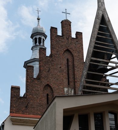 Zdjęcie nr 2: Kościół orientowany, murowany z cegły i kamienia, jednonawowy z trójprzęsłowym prezbiterium zamkniętym wielobocznie, sklepionym krzyżowo-żebrowo. Od północy umieszczona prostokątna, piętrowa zakrystia sklepiona kolebkowo (pięterko nad zakrystią dodane w 1885), dostępna kamiennym portalem o wykroju prostokątnym od strony wschodniej. Ściana północna zakrystii zakończona schodkowo z dekoracją blendową. Również od północy, na szerokości nawy do kościoła przylega prostokątna kaplica nakryta dachem czterospadowym zwieńczonym czworoboczną wieżyczką dostępna od zachodu przez prostokątną kruchtę z portalem o wykroju prostokątnym ujętym dwulalkowymi, kamiennymi balaskami. Kruchta zwieńczona trójkątnym przyczółkiem, na którym kamienny krzyż. Trójprzęsłowa nawa wyższa i szersza od prezbiterium i przesunięta w stosunku do jego osi ku stronie północnej, nakryta stropem. Północny mur nawy w części zachodniej poszerzony do pewnej wysokości dla pomieszczenia w jego grubości schodów prowadzących na chór muzyczny. Okna prostokątne zamknięte łukiem półkolistym. Zachodni i wschodni szczyt nawy zamknięty schodkowo. Od strony wschodniej trzy ostrołukowe blendy, w środkowej, wyżej od bocznych umieszczona tarcza herbowa z wizerunkiem św. Stanisława oraz Orła Białego. Od południa do nawy przylega prostokątna kruchta z kamiennym, ostrołukowym portalem nakryta dachem pulpitowym. Od strony zachodniej do bryły kościoła dostawiona prostokątna, współczesna kruchta wraz z chórem muzycznym (dobudowana w 1966) dostępna portalem o wykroju prostokątnym, nakryta dwuspadowym dachem. W ścianach bocznych wąskie, smukłe okna w kształcie stojącego prostokąta. Ponad kruchtą ażurowa dzwonnica na rzucie trójkąta zwieńczona krzyżem. Wieżyczka na sygnaturkę na rzucie ośmioboku zwieńczona barokowym hełmem z glorietą i krzyżem. Od zewnątrz kościół częściowo tynkowany, nawa i prezbiterium opięte szkarpami. Dachy kryte dachówką oraz blachą (część wschodnia prezbiterium).